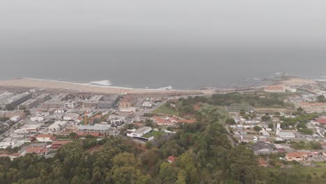aerial - foggy view of vila nova de gaia beach, buildings, and coastline in portugal