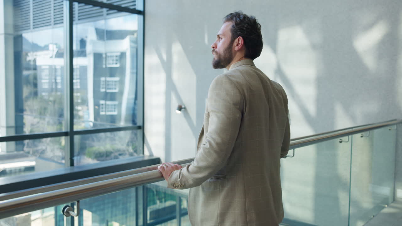 Man in suit looking out office window