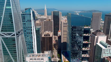 Innenstadt-Von-San-Francisco-Mit-Klarem-Blauen-Himmel,-Modernen-Wolkenkratzern-Und-Blick-Auf-Die-Bucht-In-Der-Ferne,-Mittag,-Luftaufnahme