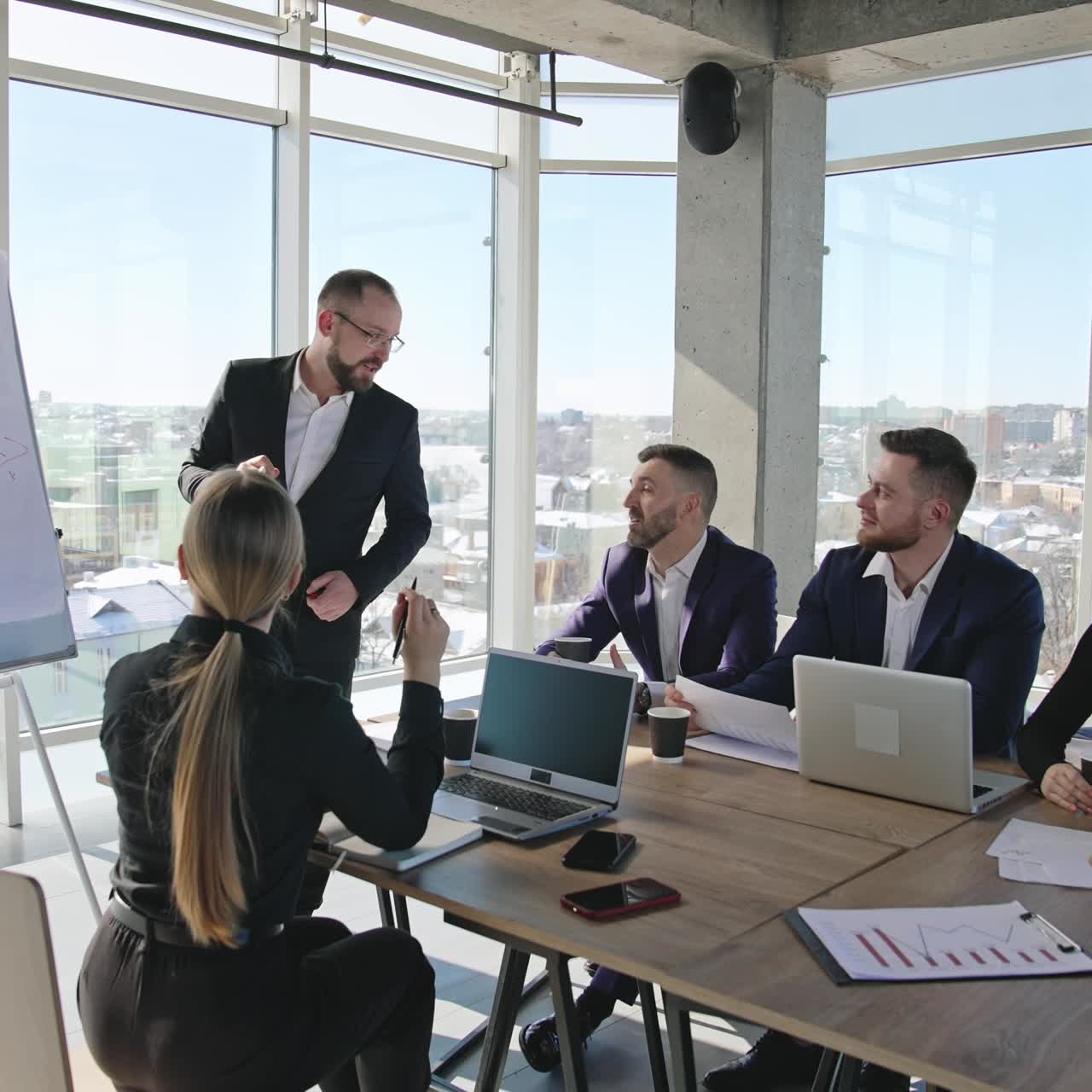 Informal and light atmosphere at the office meeting. The presenter makes speech and explains the chart in front of the teammates. Circular background
