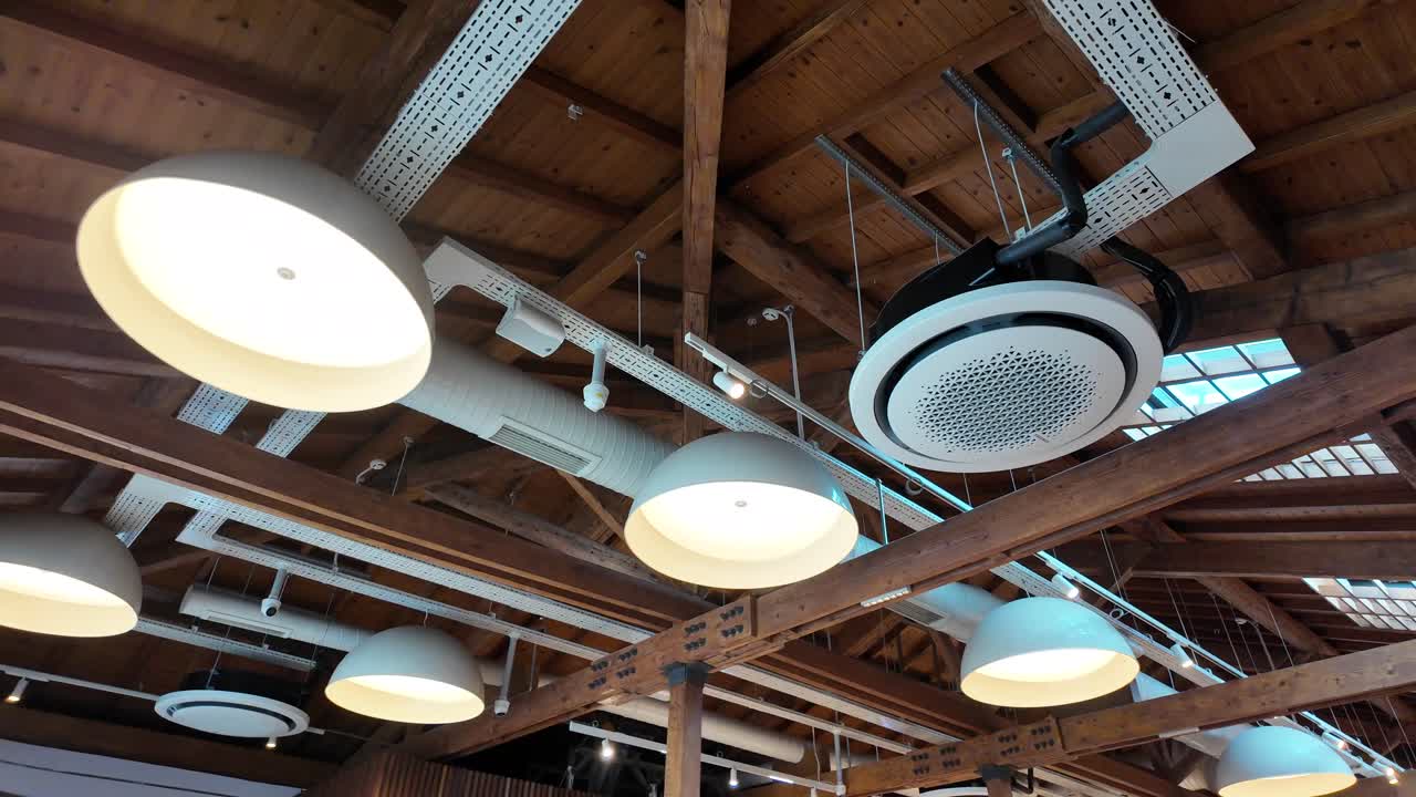 techo de restaurante de estilo industrial con vigas de madera y luces colgantes