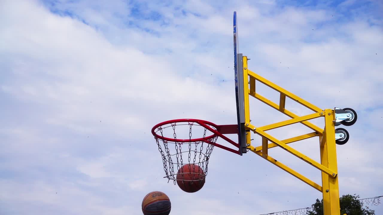 Pallacanestro da strada. La palla vola verso il canestro. Al rallentatore