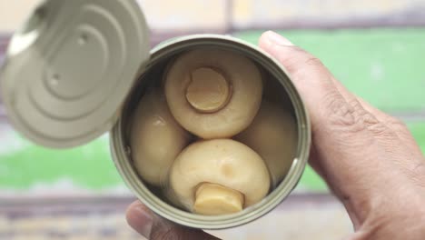 open tin can of canned mushrooms