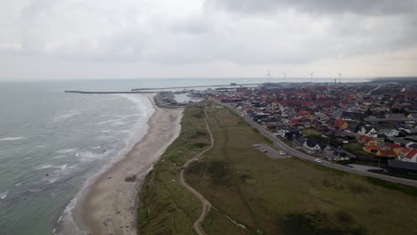 over flight of hirtshal village beach coastline on cloudy day with wind turbines