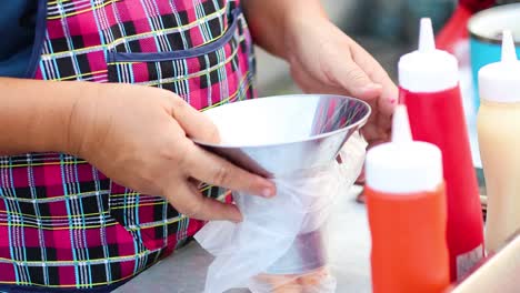 woman packaging sausages with condiments