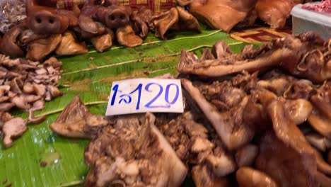 various pork cuts displayed at a market stall