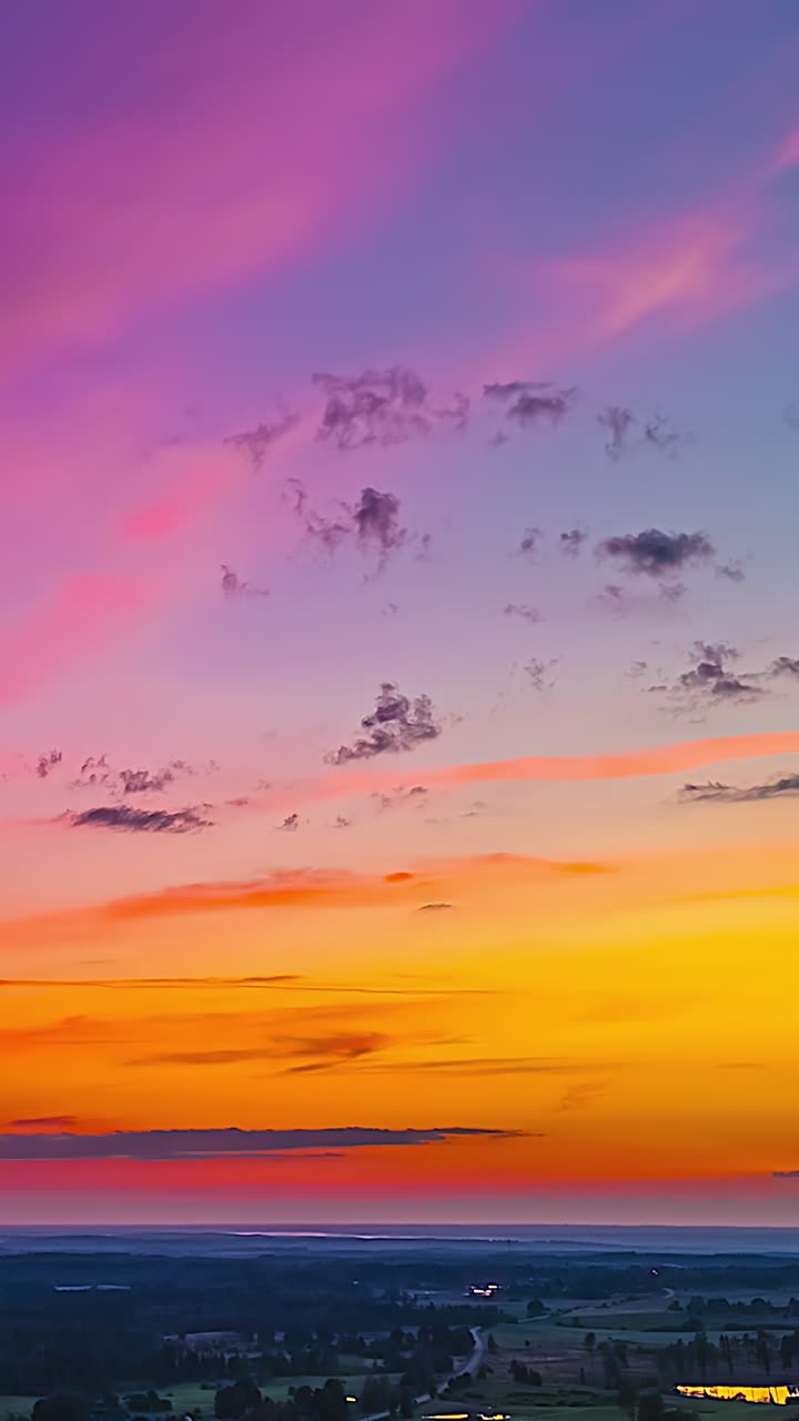 Cielo pastello al tramonto con nuvole rosa e arancioni che sfumano in tonalità viola, sfondo nuvoloso, verticale