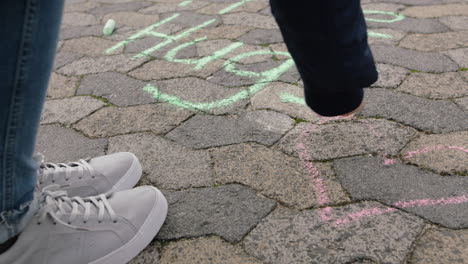 young woman hand drawing using pink chalk writing free hugs happy teenage girl on playground concept