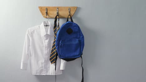 school uniform and school bag hanging on hook 4k