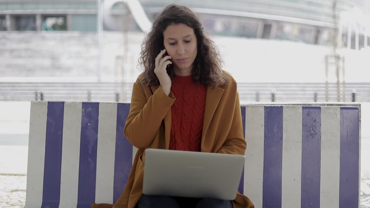 mujer enfocada usando dispositivos digitales al aire libre