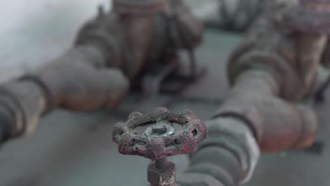 old and rusted faucet and metal pipes. tilt shot from top to bottom.