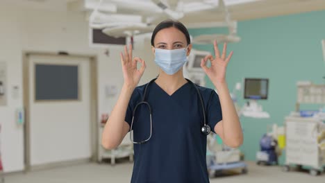 happy indian female doctor showing okay sign with mask on