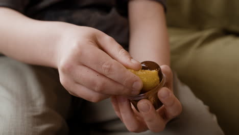close-up of hands dipping a snack into chocolate sauce