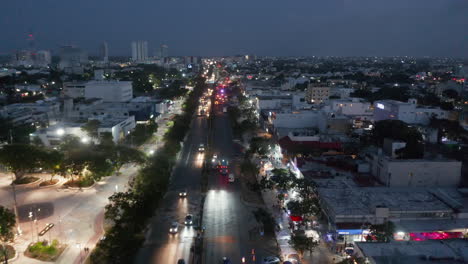 Forwards-fly-above-busy-street-at-night.-Cars-driving-on-multilane-road.-Night-life-in-neighbourhood.-Cancun,-Mexico