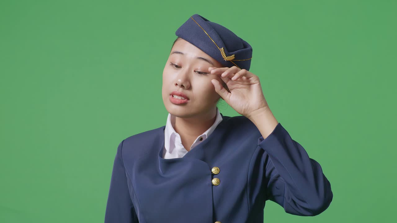 녹색 스크린 배경 스튜디오에 서있는 동안 을 고 피곤한 아시아 여성 에어 호스테이스의 클로즈업