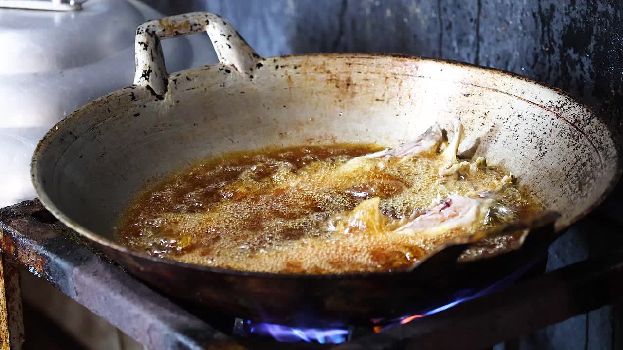 Sequenza di pesce che frigge in olio caldo sul fornello
