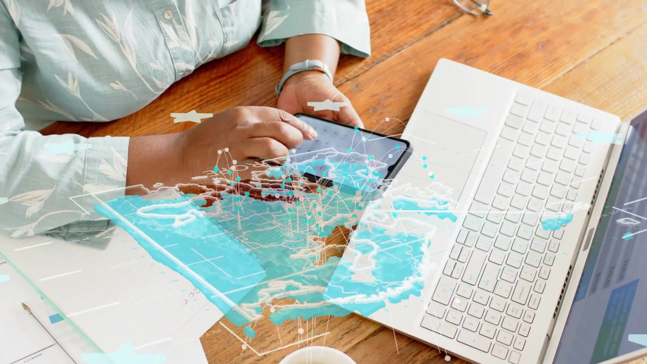Mulher pegando o telefone e deslizando a tela, causando uma sobreposição de mapa azul que se alinha com o laptop para tecnologia.