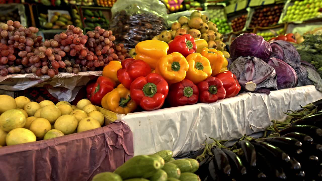 Vibrant piles of locally grown vegetables and fruits are artfully arranged at an outdoor stall in Luxor's traditional market