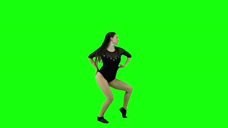 stunning female dancer practicing a dance in front of a green screen