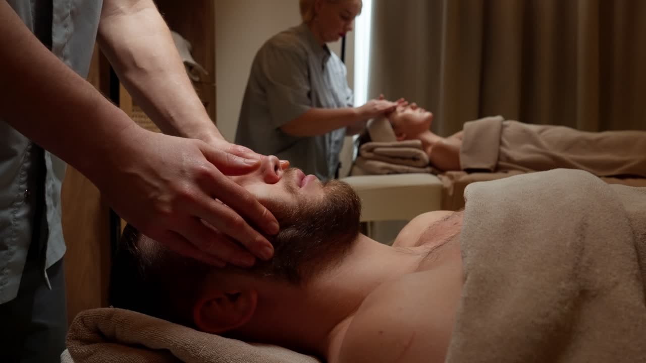 Pariskunta nauttimassa rentouttavista kasvohieronnoista wellness-kylpylässä