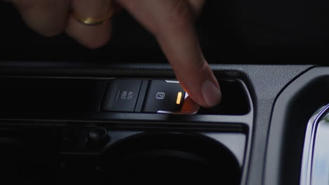 close-up pressing the handbrake button on the inside a car