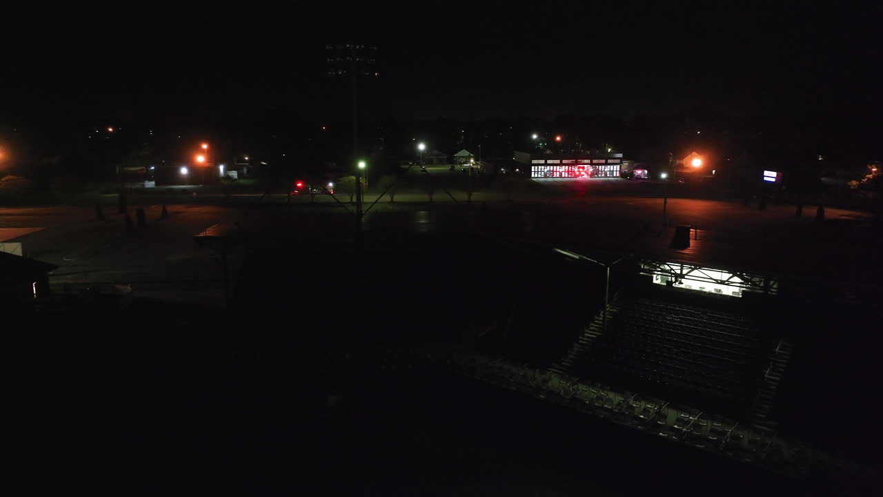 Ripresa aerea di autopompe che escono da una stazione dei pompieri di notte. Campo lungo