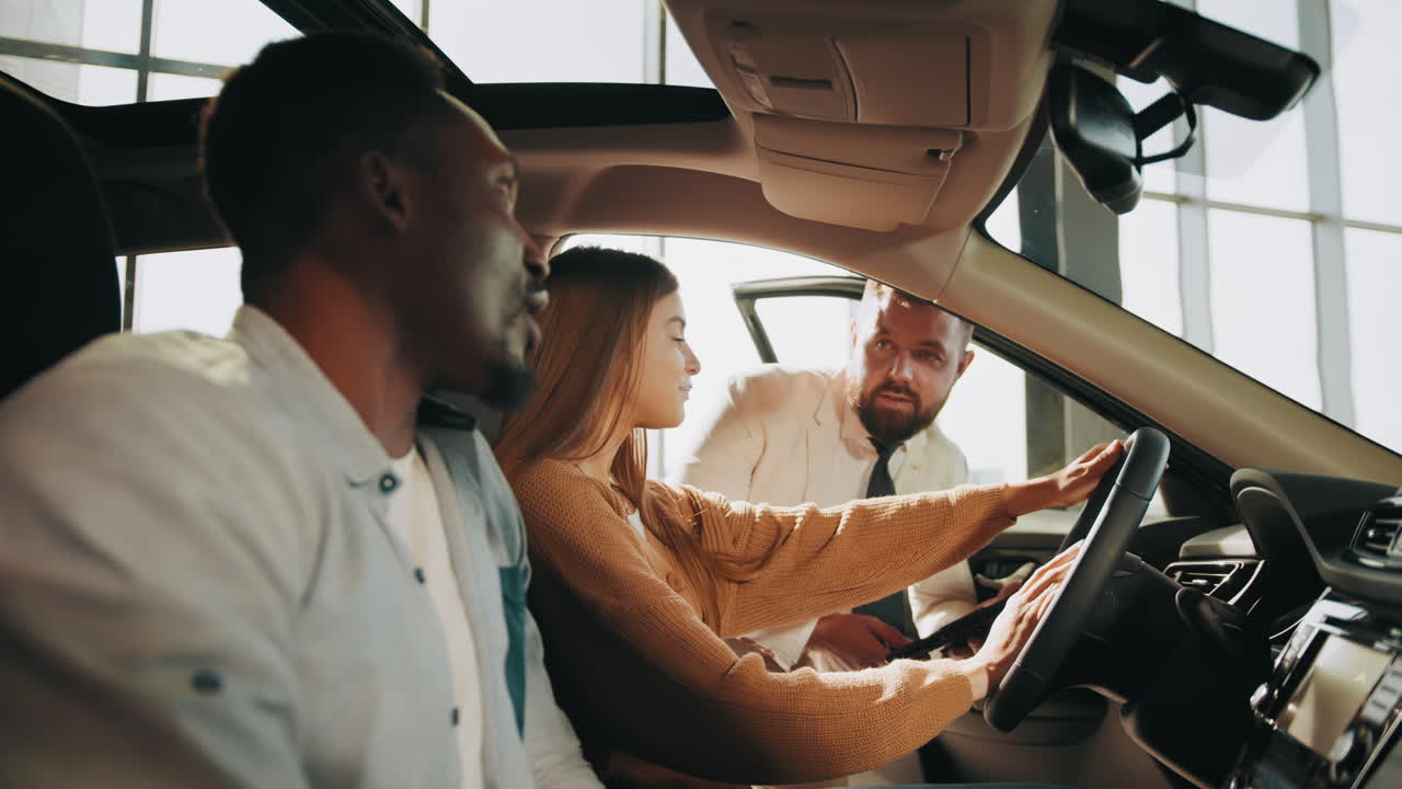 una pareja mirando un coche con un vendedor en una sala de exhibición