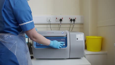 usando una máquina de muestra de sangre en un laboratorio