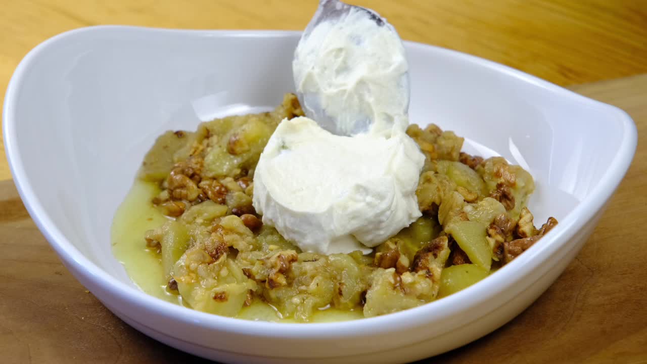 셰프는 접시에 있는 음식에 요구르트를 넣습니다.