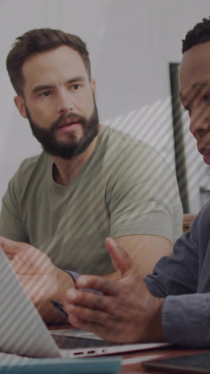 Right-hand man starting talk gesturing on laptop map overlay showing business data left man nodding
