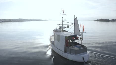 aerial close-up of a small fishing boat in calm ocean water at öckerö island municipality in gothenburg archipelago, sweden.
