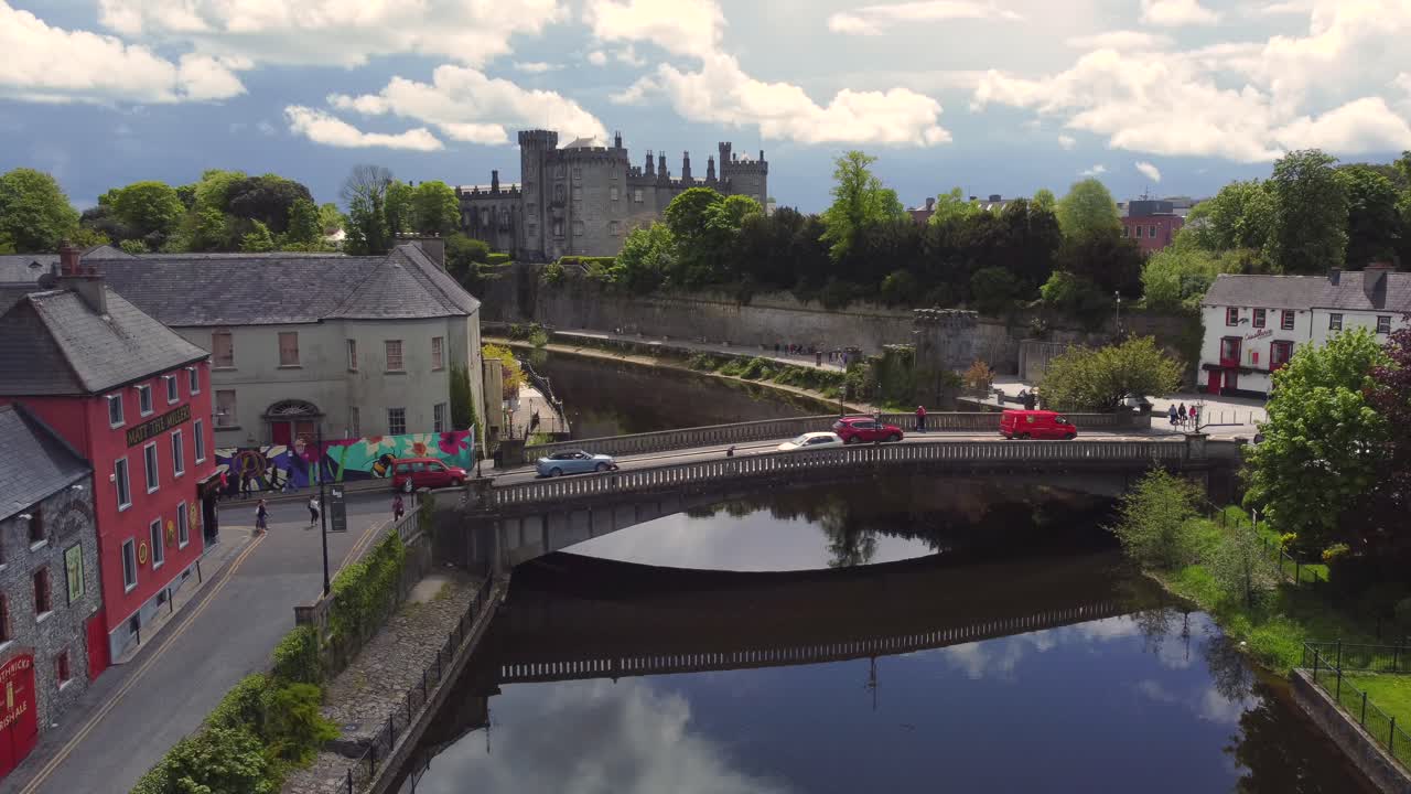 흐린 날 강 위를 맴도는 동안 성이 있는 마을의 공중 영상