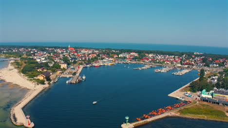 drone flying towards the marina in the city of jastarnia in poland with baltic sea in the background