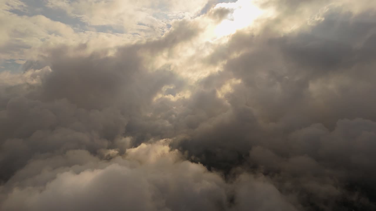 Dramatic aerial captures sun rays piercing dense stormy cloud cover