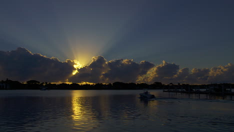 small motor boat leaves from dock at sunrise in south florida, u