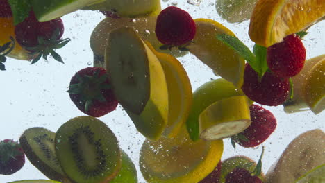 mix fruits dropped water in super slow motion closeup. various juice ingredients