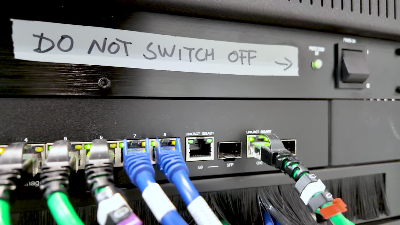 Busy network switch with multiple ethernet cables connected and lit status indicators