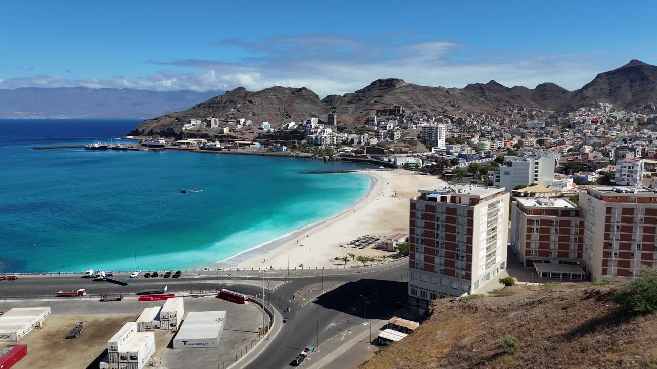 Vista panoramica aerea con drone della baia di Mindelo, Sao Vicente. Architettura della città costiera, spiaggia di Praia da Laginha e il profondo oceano Atlantico circondato da picchi vulcanici a Capo Verde.