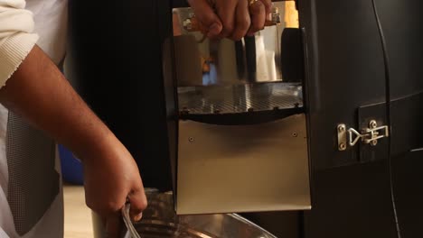 employee is taking the ready bean to the package area using metal bucket.
