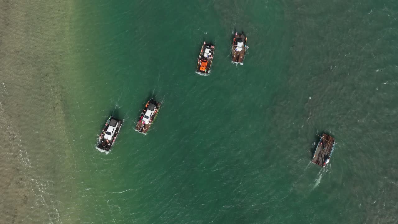 브라질 북부 표면에 작은 파도를 일으키는 바람과 함께 크고 얕은 강을 건너는 자동차를 운반하는 작은 페리 보트 그룹의 공중 조감도