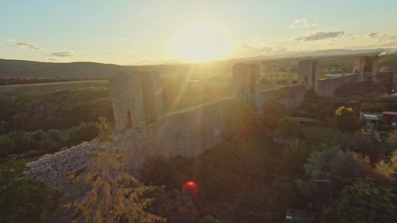 vuelo rápido sobre la comuna de monteriggioni al atardecer, provincia de siena, italia
