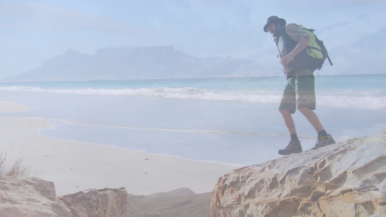 Male hiker stepping across sunlit coastal rocks, with animated map lines and travel marketing icons