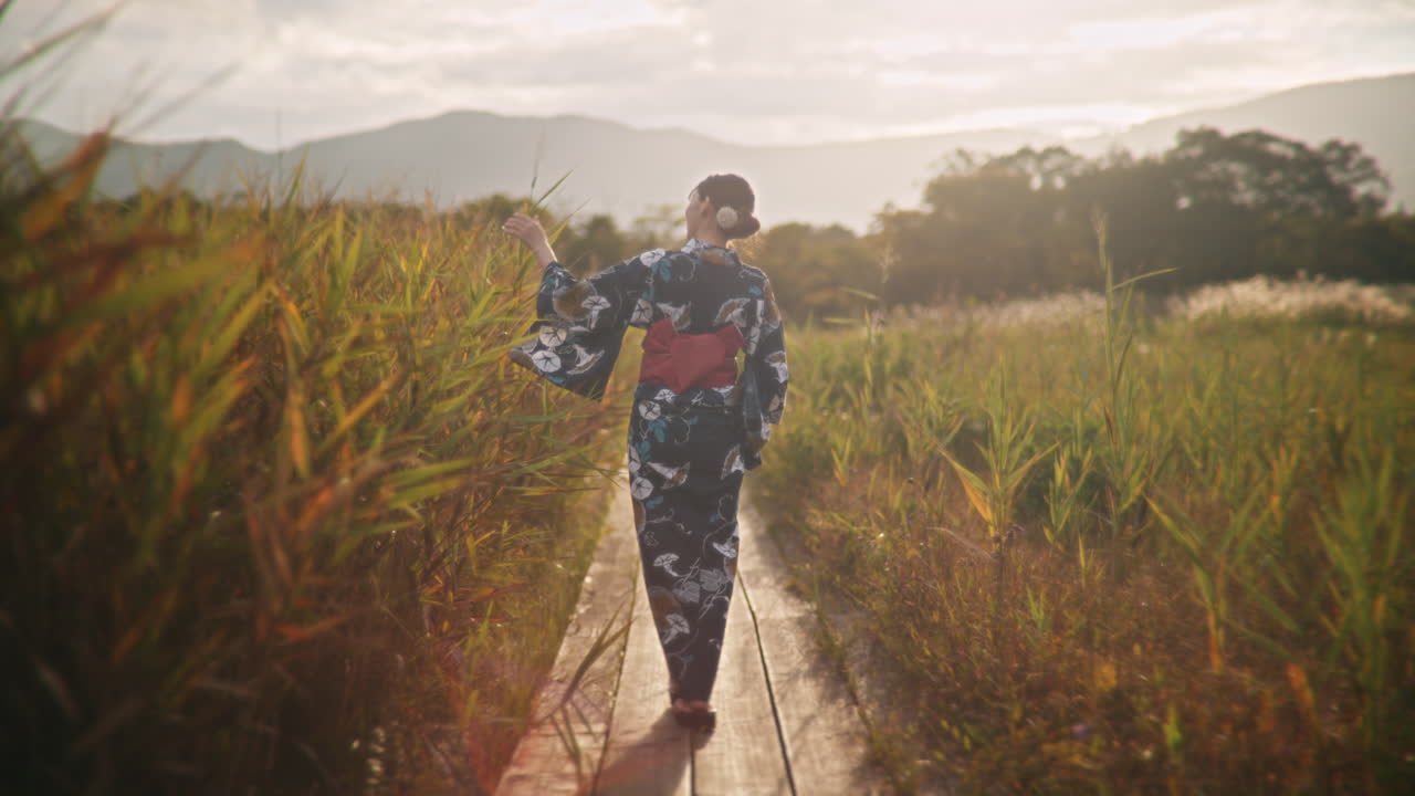 Donna in kimono che cammina attraverso un campo