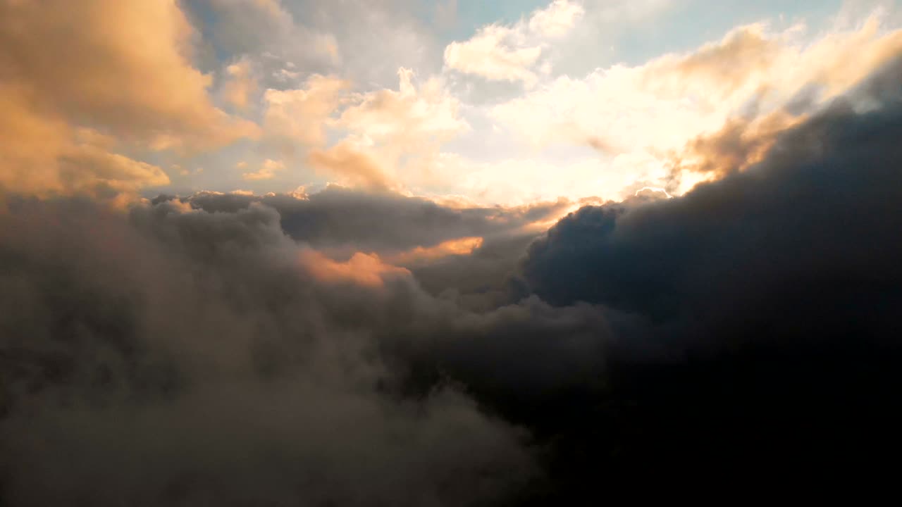 la cámara se extiende a través de las nubes de lluvia de la noche al atardecer por encima de los niveles de nubes. fabuloso vuelo en las nubes. vista aérea
