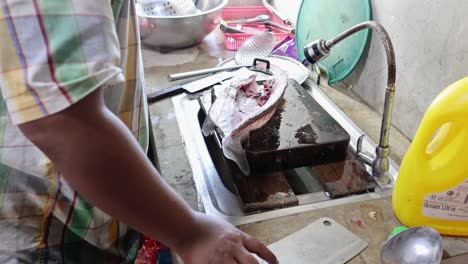 person methodically gutting and cleaning a fish.