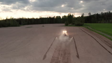 aéreo - tractor sembrando semillas al anochecer, hedemora, suecia, plano amplio hacia adelante