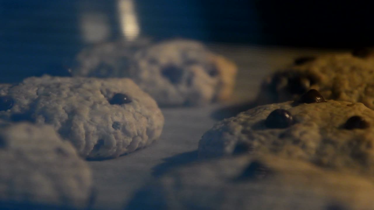 초콜릿 방울과 함께 가정용 오트밀 쿠키가 뜨거운 오븐에서 고 있습니다. 전체 과정의 비디오를 가속화하십시오.