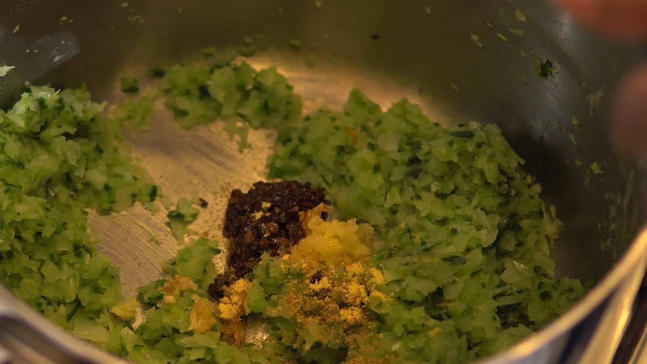 Cooking a delicious dish with minced zucchinis, garlic and chili - Close up