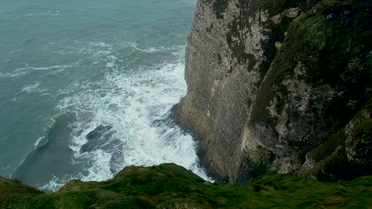 Waves crash against the rugged Irish cliffs on a moody December day