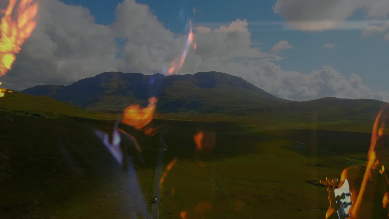 vehicle traveling winding highland road, showing orange green lens flares, education presentation